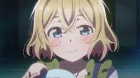 Jovem anime loira com bochechas rosadas e grandes olhos cintilantes, sorri gentilmente segurando um objeto esférico azul claro num cenário escuro.