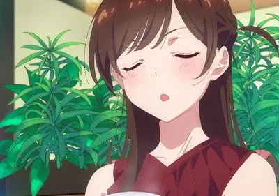 Jovem anime de cabelo castanho, olhos fechados e bochechas rosadas, rodeada por plantas. Clima sereno.