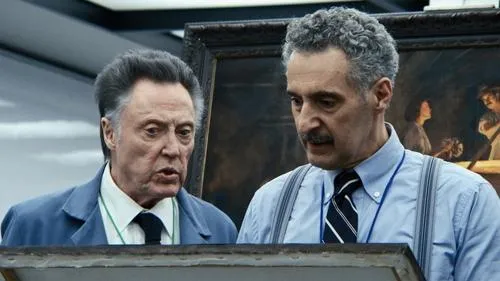 Dois homens idosos com expressões sérias examinam algo fora do quadro. Um de paletó azul,outro de camisa e suspensórios. Fundo com pintura escura.
