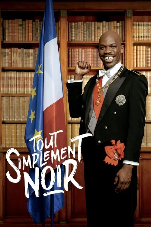 Homem negro careca sorri com dente separado, usando smoking e medalhas, punho erguido, ao lado de bandeiras francesa/UE em biblioteca.