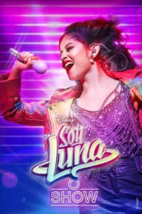 Cantora sorridente com batom vermelho e roupa brilhante segura microfone em palco vibrante com luzes rosa e roxas. Energia musical.