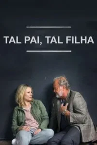 Mulher loira e homem barbudo sentados no chão, olhando um para o outro em conversa, contra fundo escuro. Clima intimista.