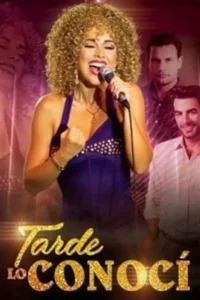 Cantora de cabelo cacheado loiro em top roxo canta com paixão. Dois homens a observam no fundo, um sério e outro sorrindo. Atmosfera musical e dramática.