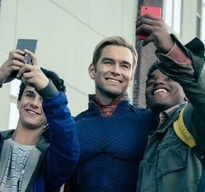 Super-herói sorridente em traje azul posa entre dois jovens fãs felizes tirando selfies com seus celulares.