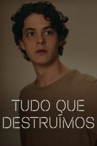 Jovem de cabelo escuro e olhos arregalados,vestindo camiseta marrom. Fundo simples e neutro,clima de suspense.