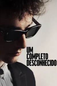 Homem de cabelo encaracolado e óculos escuros,olhando para baixo. Close-up introspectivo com fundo claro.