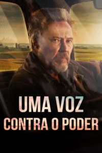 Homem barbudo e sério em um carro,olhando à frente. Paisagem rural com campos dourados e sol ao fundo. Clima dramático.