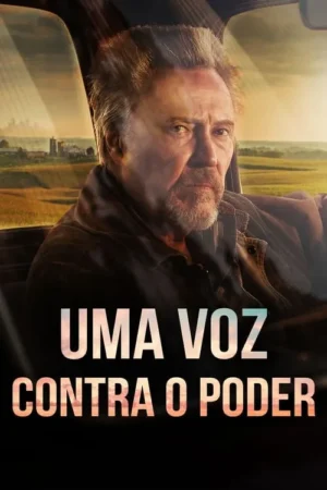 Homem barbudo e sério em um carro, olhando à frente. Paisagem rural com campos dourados e sol ao fundo. Clima dramático.
