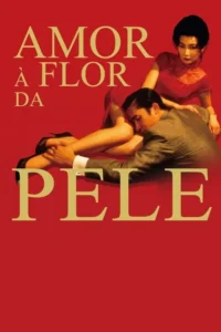 Amor à Flor da Pele 2 Fundo vermelho. Mulher de vestido vermelho sentada, homem de terno com a cabeça no colo dela, segurando seu tornozelo. Clima íntimo e intenso.