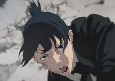 Jovem de cabelo preto e rabo de cavalo, ferido e sangrando no rosto, grita e rasteja com fúria em cenário de destruição.