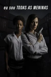 Duas mulheres de etnias diferentes,sérias,uma com arma,em cenário industrial escuro. Clima tenso.