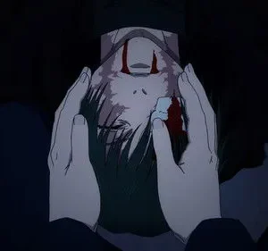 Mãos seguram o rosto pálido e ensanguentado de uma pessoa com cabelo escuro e olhos fechados. O ambiente é escuro, com tom melancólico.