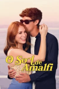 Jovem casal abraçado,com fundo de pôr do sol. Ele,de óculos escuros,beija a testa dela,que sorri feliz. Clima romântico.