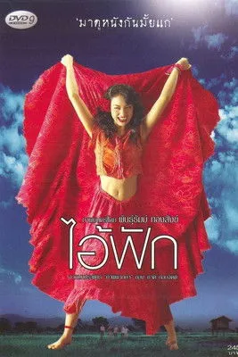 Mulher sorridente em roupa vermelha, braços erguidos com tecido vermelho esvoaçante. Cenário de campo verde e céu azul com nuvens.