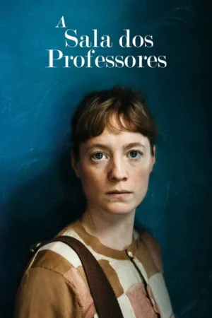 Mulher de cabelos castanhos e expressão séria olha fixamente. Veste cardigã estampado. Fundo azul escuro com marcas de giz.