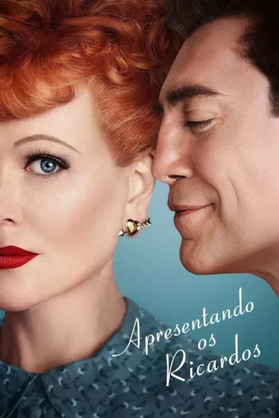 Close-up: mulher ruiva com brinco de coração e lábios vermelhos, olhar intenso. Homem moreno sorridente encosta nela. Fundo azul.