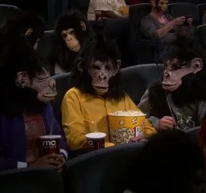 Várias pessoas usando máscaras realistas de macaco e cabelo falso assistem a um filme em um cinema escuro, comendo pipoca. Clima divertido.