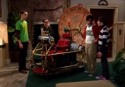 Quatro homens curiosos em um apartamento observam uma máquina do tempo steampunk com assento vermelho e grande relógio.