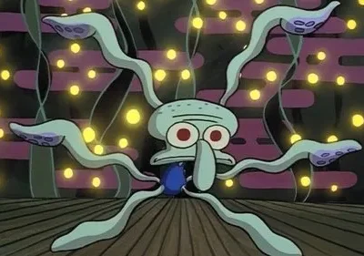 Polvo azul de olhos vermelhos e tentáculos esticados numa sala escura com luzes amarelas cintilantes. Ele parece sobrecarregado.