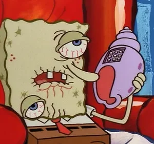 Personagem esponjoso doente, olhos vermelhos, dentes quebrados, atende telefone concha. Sentado em poltrona vermelha, parece exausto.