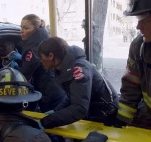 Profissionais de resgate atendem uma vítima em um carro acidentado. Bombeiros e paramédicos em cena de emergência urbana.