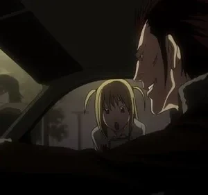 Homem ruivo sorrindo maliciosamente ao lado de mulher loira assustada em carro. Pessoas observam no fundo. Clima tenso.