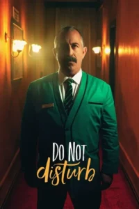 Pôster:Homem de bigode em uniforme verde de hotel em corredor escuro. Iluminação quente,olhar direto,clima misterioso.
