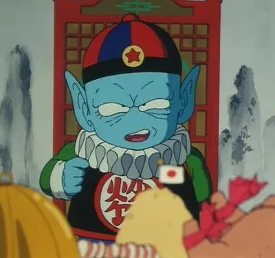 Criatura azul de orelhas pontudas, chapéu com estrela e colarinho babado, expressão séria. Fundo: porta vermelha e montanhas estilizadas.