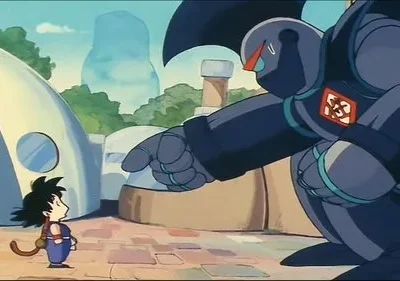 Um menino com rabo de macaco encara um robô gigante escuro que aponta para ele. Cenário de vila futurista com casas arredondadas.