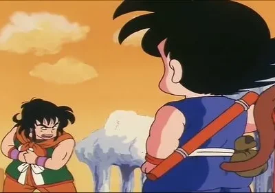 Dois personagens de anime. Um garoto de cabelo espetado, de costas com cajado, encara um homem furioso de roupa verde. Cenário árido, céu laranja.