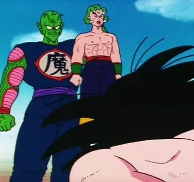 Duas figuras ameaçadoras, uma verde e outra musculosa, sobre um personagem de cabelo espetado caído. Fundo desértico e tenso.