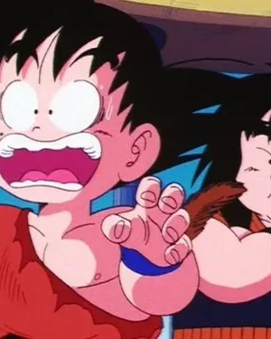 Um jovem de anime assustado, com cabelo espetado e mãos estendidas, grita. Outro garoto, ao lado, puxa sua cauda marrom. Cena cômica.