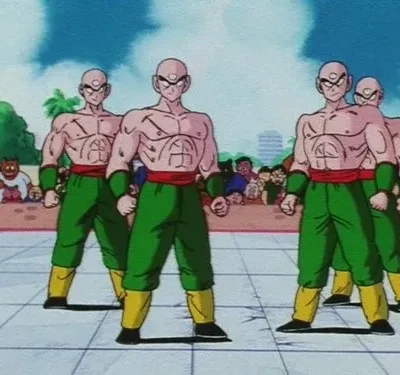 Cinco guerreiros musculosos e carecas, com três olhos, vestindo verde e vermelho, estão em um ringue de luta, com público ao fundo.