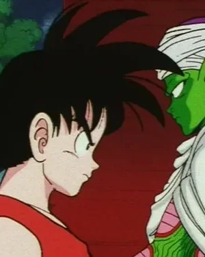 Garoto de cabelo espetado e camisa vermelha encara um ser verde com turbante. Clima tenso e intenso entre os dois.