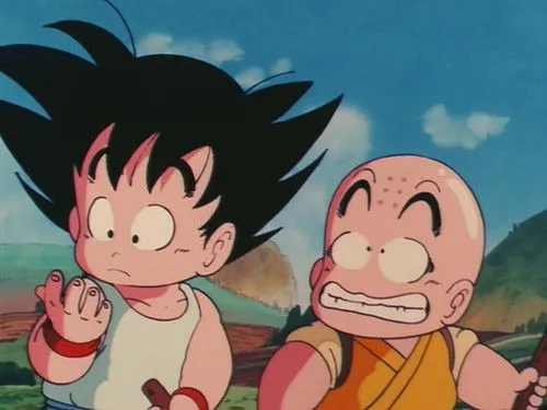 Dragon Ball – T01E18:Treinamento ao Estilo de Mestre Kame 1 Dois jovens personagens de anime:um com cabelo preto espetado e outro careca. Ambos com olhos arregalados,parecem surpresos em um fundo campestre.