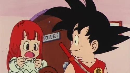 Dragon Ball – T01E35:Suno,a Menina da Aldeia do Norte 1 Uma garota ruiva em choque,punhos cerrados,olha para um menino de cabelo espetado sorrindo. Ao fundo,uma porta com placa TOILET. Humor e surpresa.