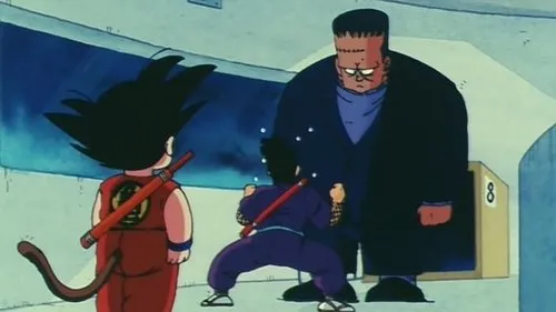 Dragon Ball – T01E39:O Encontro Com o Misterioso Androide Nº 8 1 Três personagens de anime:dois garotos com cauda e bastões encaram um homem gigante e imponente com cabeça quadrada,em um ambiente simples.