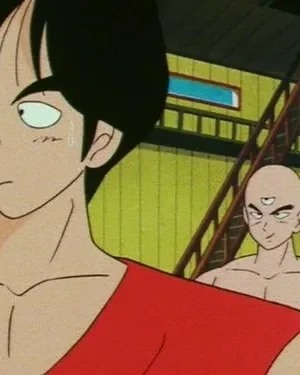 Dois homens em estilo anime. Um jovem com camisa vermelha parece preocupado. Atrás, um careca de três olhos e musculoso sorri confiante.