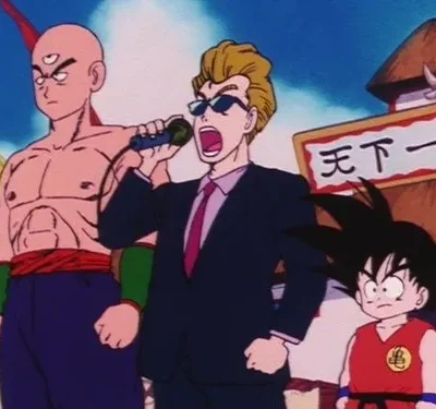 Um lutador careca de três olhos, um apresentador em terno gritando no microfone, e um menino com cauda. Cenário de torneio.