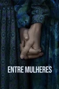Mãos de duas mulheres se entrelaçam em primeiro plano,sobre tecidos florais em tons escuros. Evoca conexão e seriedade.