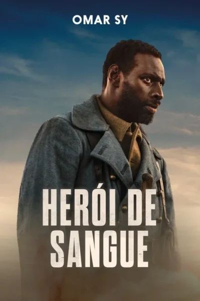 Homem negro barbudo em uniforme militar cinza, com um rifle, olha intensamente para o lado, contra um céu nublado.