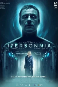 Pôster azul escuro. Rosto sério de um homem flutua acima de mulher loira com casaco,em corredor futurista com luzes azuis. Clima sci-fi.