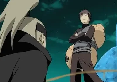 Um homem de cabelo claro e capa escura de costas. Em frente, um jovem de braços cruzados, com cabaça às costas, sob céu noturno.