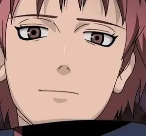 Close-up de personagem de anime com cabelo rosa espetado, olhos castanhos e expressão calma, em fundo escuro e desfocado.