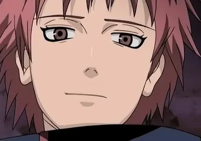 Close-up de personagem de anime com cabelo rosa espetado, olhos castanhos e expressão calma, em fundo escuro e desfocado.