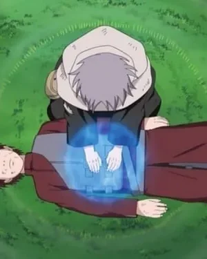 Jovem de capuz cinza ajoelhado sobre outro de cabelo vermelho com marcas no rosto, aplicando energia azul no peito em gramado verde.