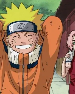 Um jovem loiro de laranja sorri feliz, mãos na cabeça, ladeado por uma garota de cabelo rosa e um garoto de cabelo escuro. Todos estão sujos, em cenário urbano.