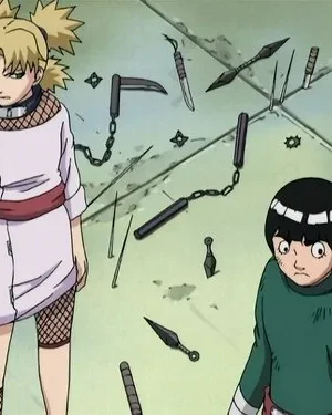 Mulher loira irritada com leque e homem chocado de cabelo tigela num chão cheio de armas. Pós-batalha de ninjas.