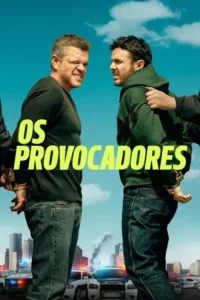 Dois homens algemados com expressões tensas em cenário urbano com viaturas policiais e céu azul. Clima de ação.