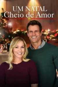 Casal sorridente em primeiro plano:mulher loira e homem. Fundo natalino festivo e borrado com árvore e luzes.
